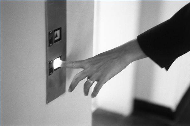 Mujer presiona botón de ascensor