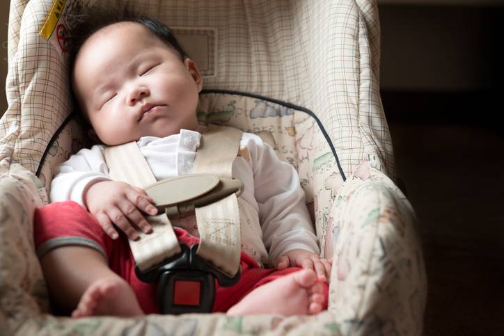 Infant fastened with seat belt for safety purpose in car seat