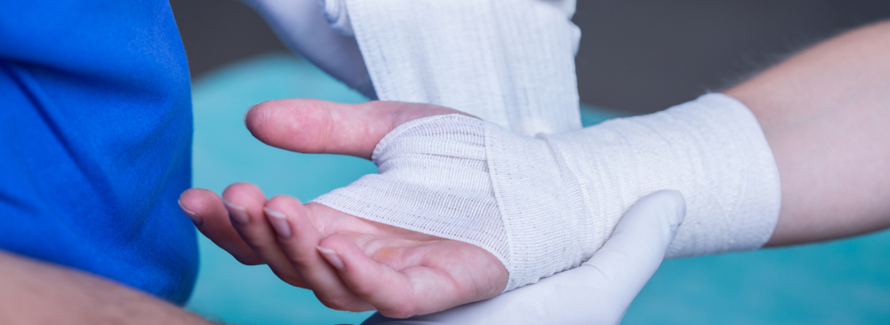 Close-up of male doctor bandaging a hand
