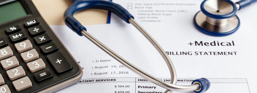 A medical bill with a stethoscope and calculator on top of it