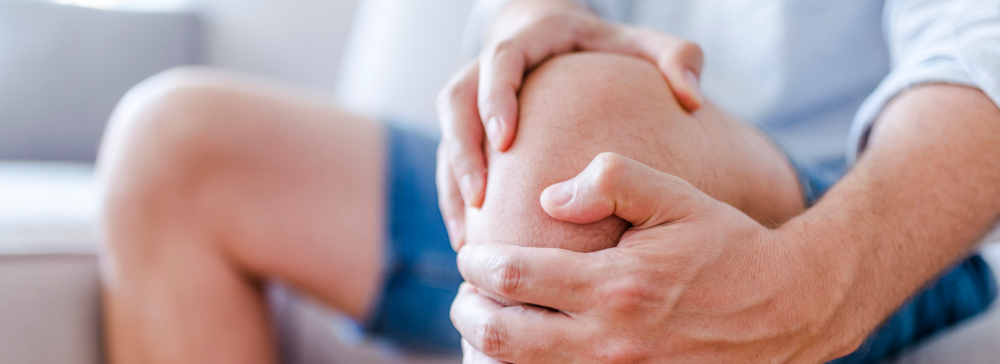 A man holding his injured knee in pain